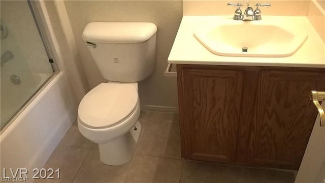 bathroom featuring tile flooring, vanity, and toilet