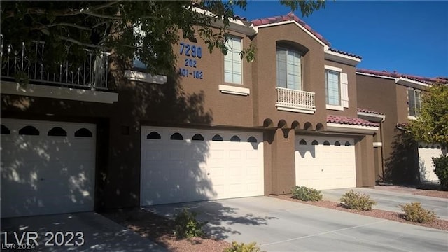 view of front of home featuring an AC wall unit and a garage