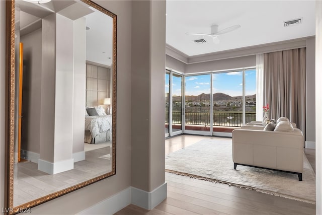 living room with wood-type flooring, ceiling fan, and crown molding