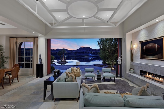 tiled living room featuring a mountain view, coffered ceiling, and a high end fireplace