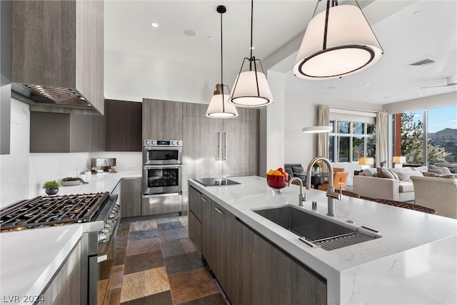 kitchen featuring a center island, appliances with stainless steel finishes, wall chimney exhaust hood, sink, and dark tile floors