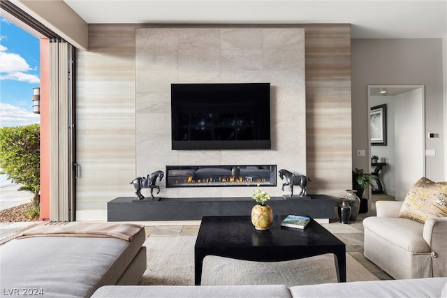 living room with a fireplace and tile walls