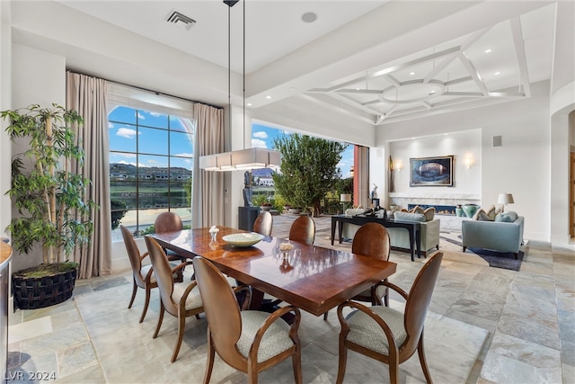 tiled dining space featuring coffered ceiling and beamed ceiling