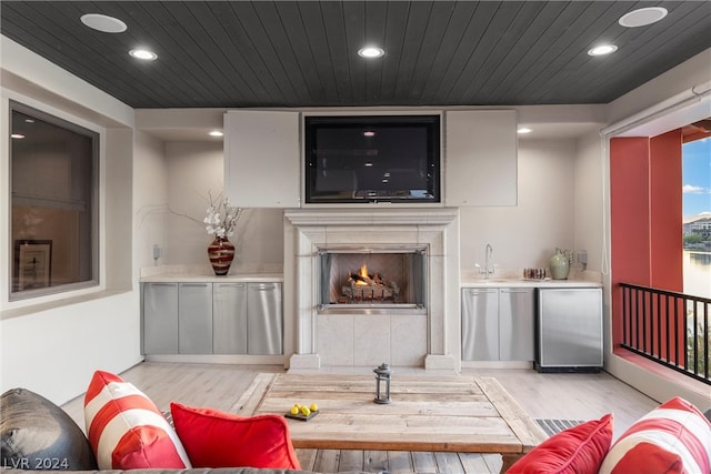 living room with sink, light hardwood / wood-style flooring, and wooden ceiling