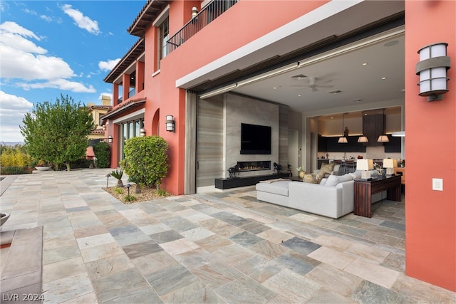 exterior space featuring outdoor lounge area, a balcony, and ceiling fan