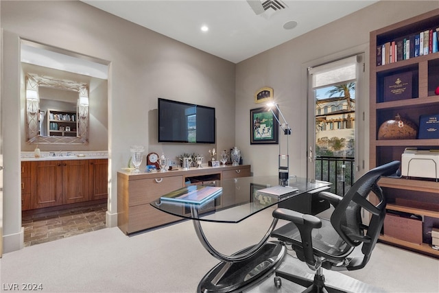 office with a wealth of natural light, sink, and light colored carpet