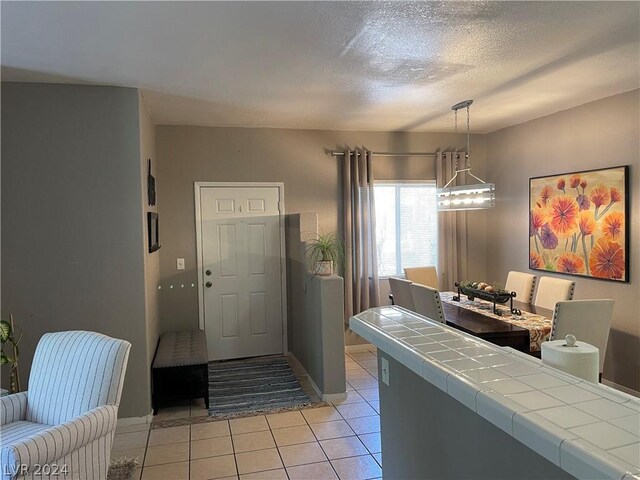 tiled foyer featuring a textured ceiling