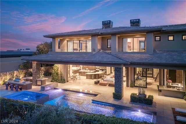 back house at dusk with a patio