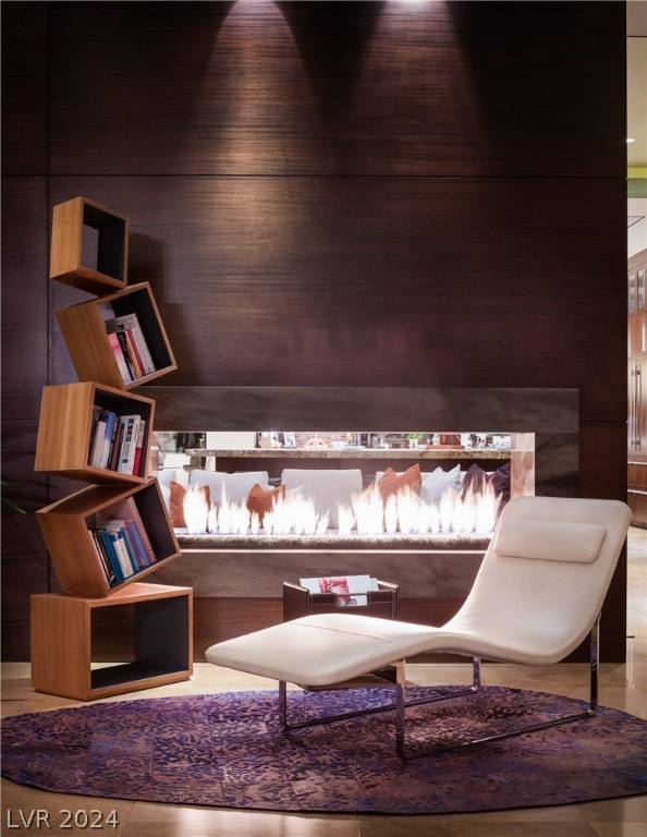 living area featuring wooden walls and light tile floors