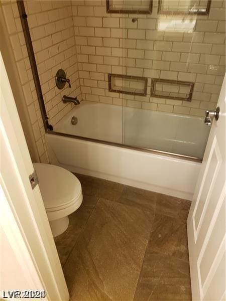 bathroom featuring tile patterned floors, shower / bath combination with glass door, and toilet