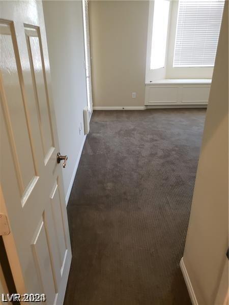 unfurnished room featuring dark colored carpet