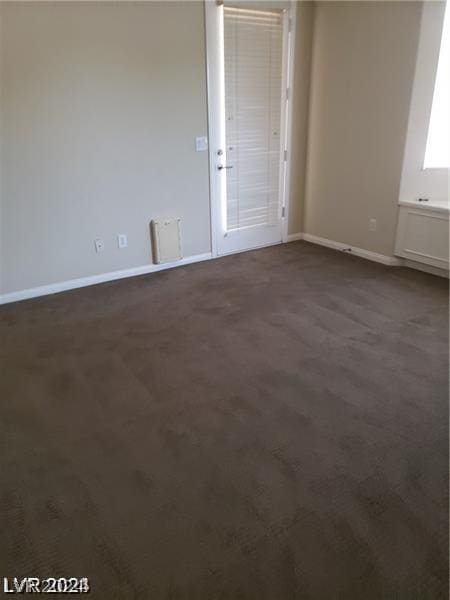 spare room featuring dark carpet