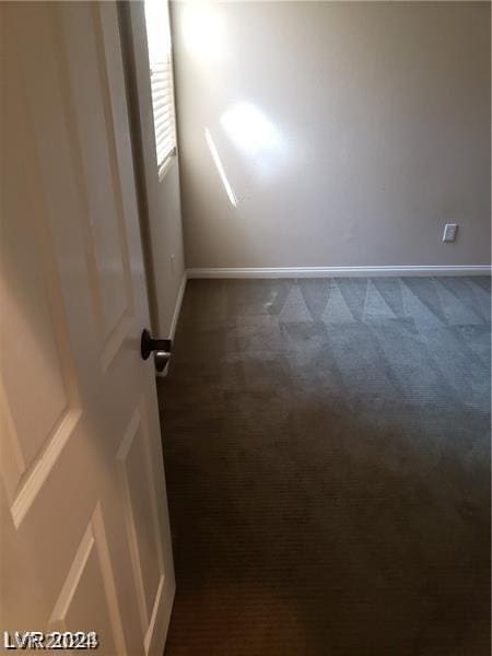 empty room with dark colored carpet