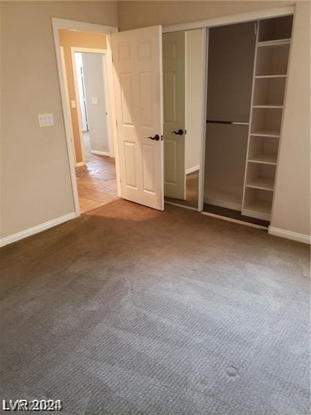 unfurnished bedroom featuring carpet flooring and a closet