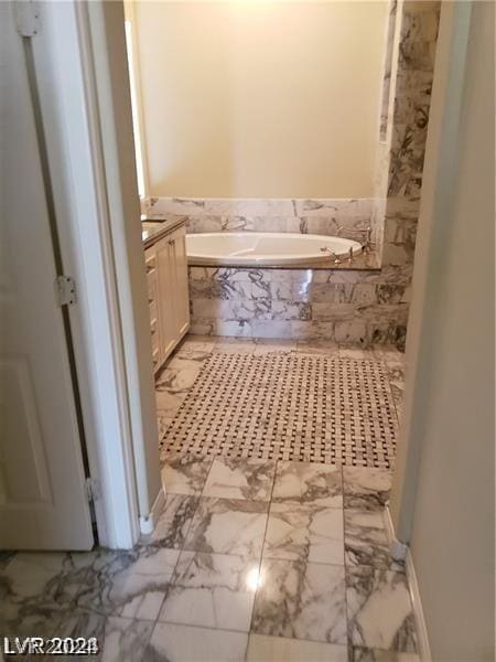 bathroom with vanity and a relaxing tiled tub