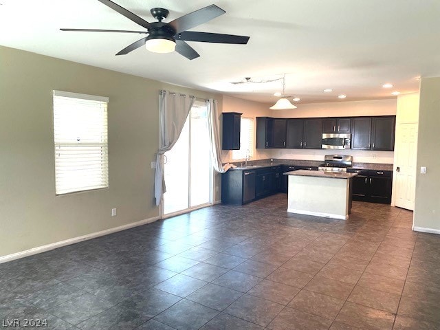 kitchen with a kitchen island, dark tile flooring, range, sink, and pendant lighting