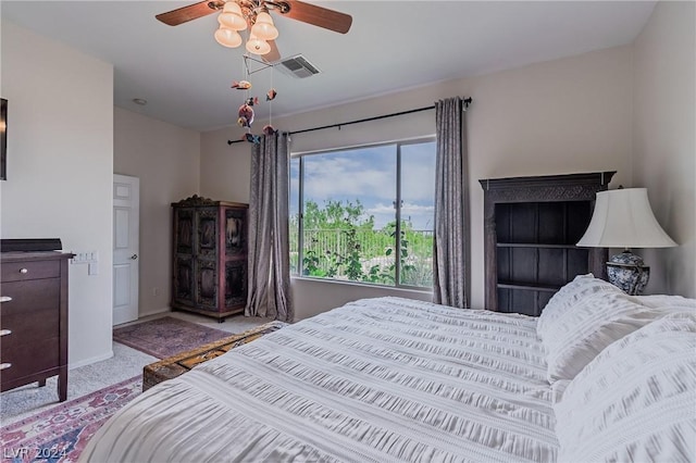 bedroom featuring ceiling fan, visible vents, baseboards, and light colored carpet