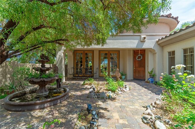 property entrance featuring stucco siding and french doors