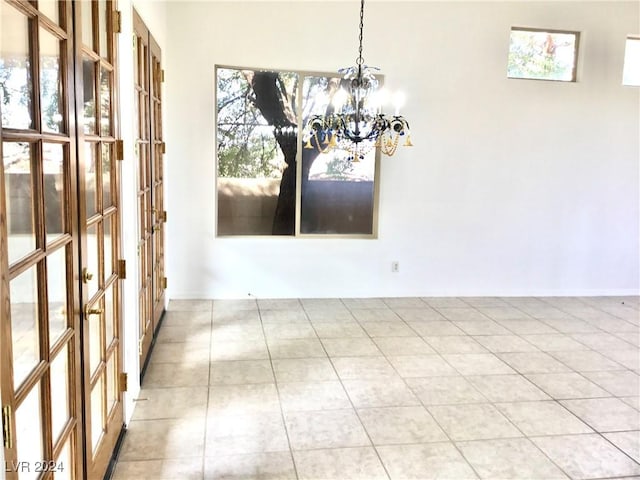 unfurnished dining area with an inviting chandelier and light tile patterned floors