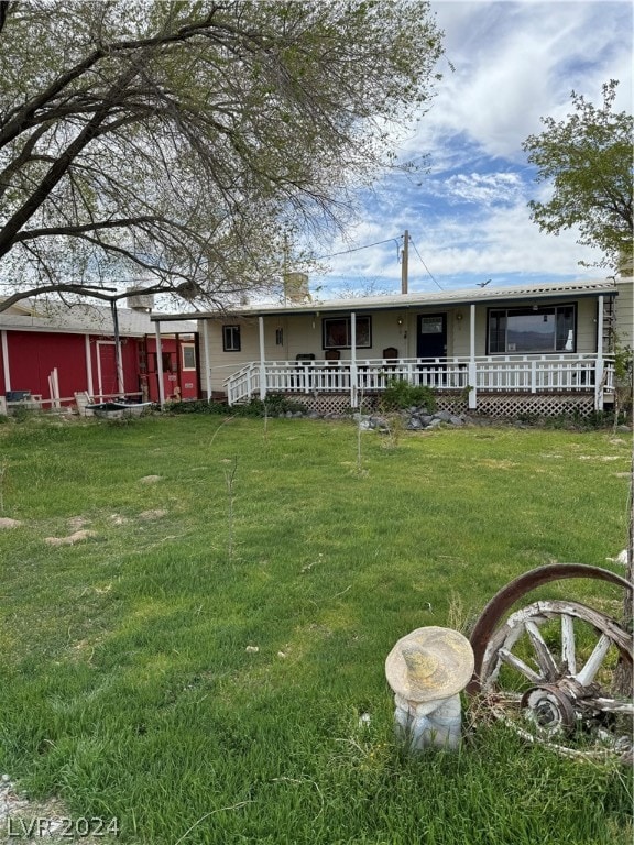 rear view of property featuring a lawn