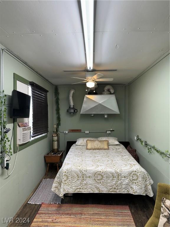 bedroom with dark hardwood / wood-style floors, cooling unit, and ceiling fan