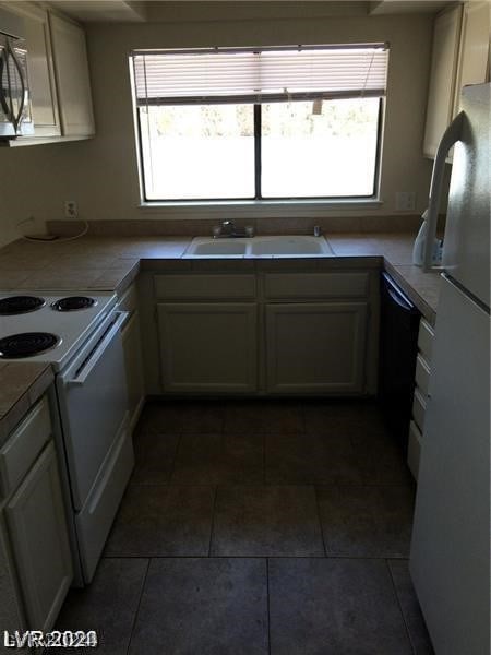 kitchen featuring tile flooring, sink, appliances with stainless steel finishes, and plenty of natural light