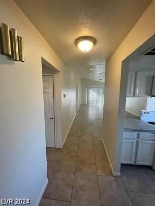 corridor featuring dark tile floors