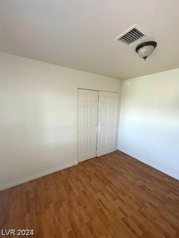 unfurnished bedroom with a closet and dark hardwood / wood-style floors