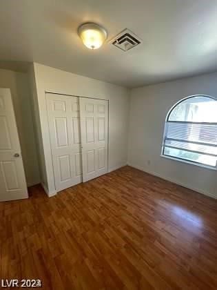 unfurnished bedroom with a closet and dark wood-type flooring