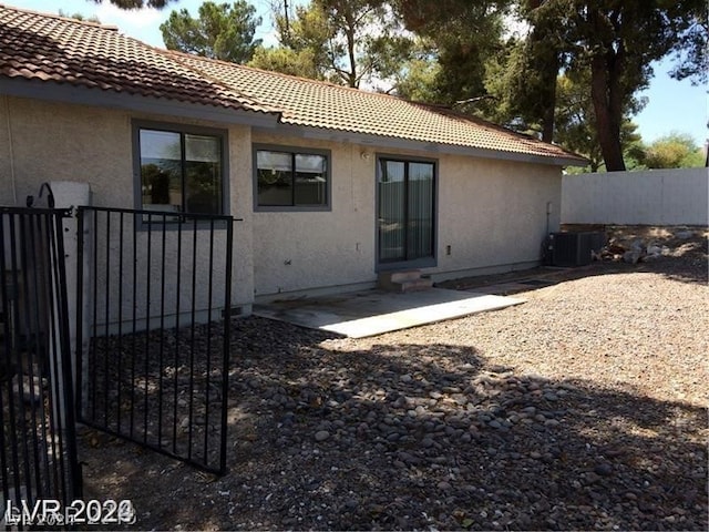 rear view of house featuring central AC unit and a patio