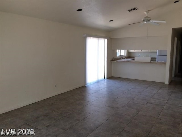 tiled spare room featuring ceiling fan and vaulted ceiling