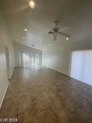 unfurnished room with dark tile flooring and ceiling fan