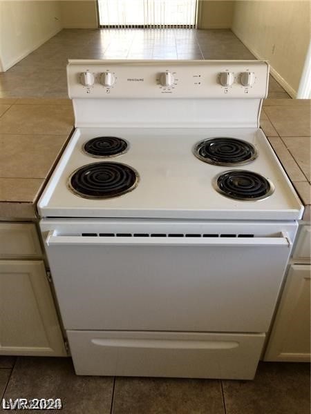 interior details with tile flooring and electric range