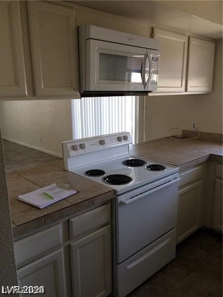 kitchen featuring white electric stove and dark tile floors