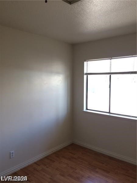 unfurnished room featuring a textured ceiling and hardwood / wood-style floors