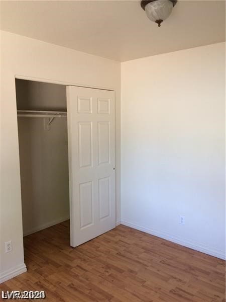 unfurnished bedroom with a closet and hardwood / wood-style floors