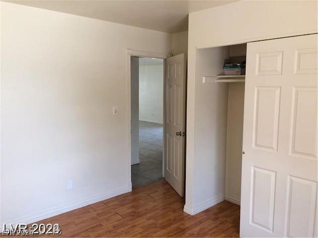 unfurnished bedroom with a closet and hardwood / wood-style flooring