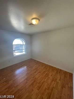 unfurnished room with hardwood / wood-style flooring