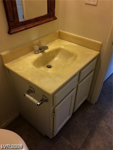 bathroom with vanity with extensive cabinet space, toilet, and tile floors