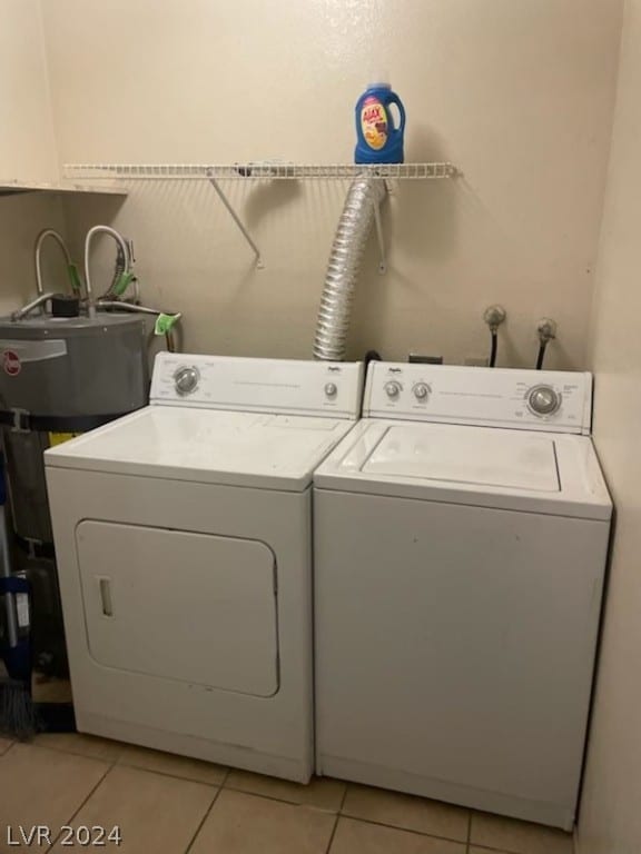 laundry room with light tile floors and washing machine and clothes dryer