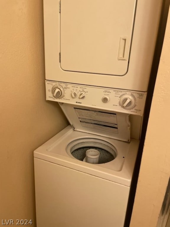 clothes washing area featuring stacked washing maching and dryer