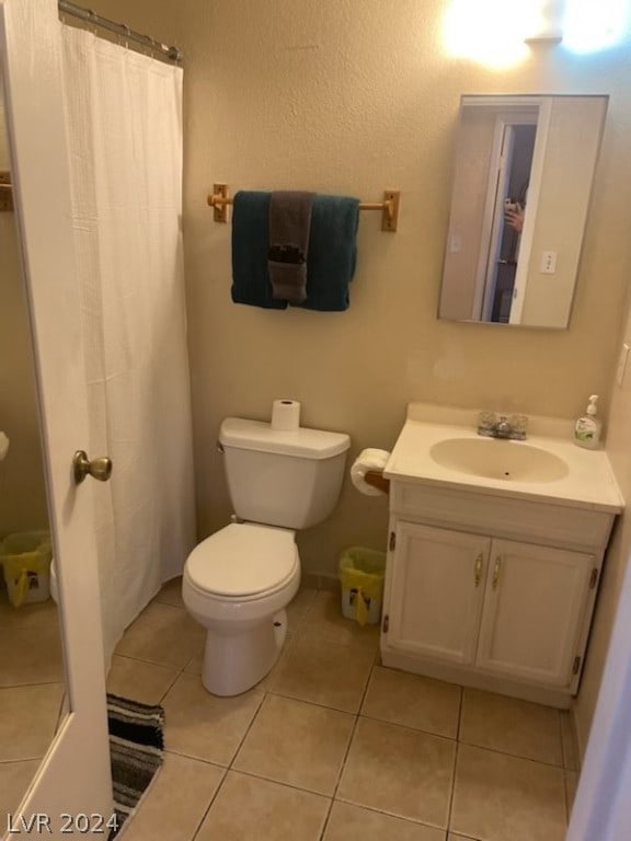 bathroom with tile flooring, vanity, and toilet