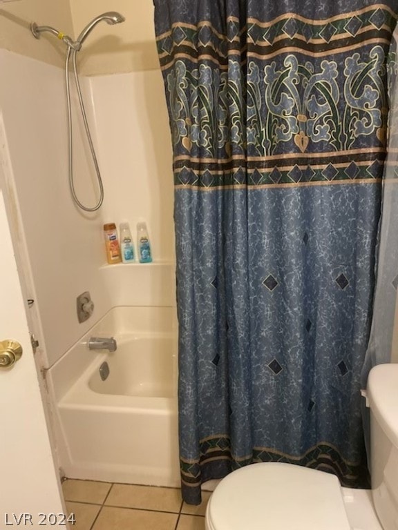 bathroom with tile floors, toilet, and shower / bath combo with shower curtain