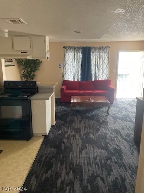 kitchen with black electric range oven, carpet flooring, and white cabinetry