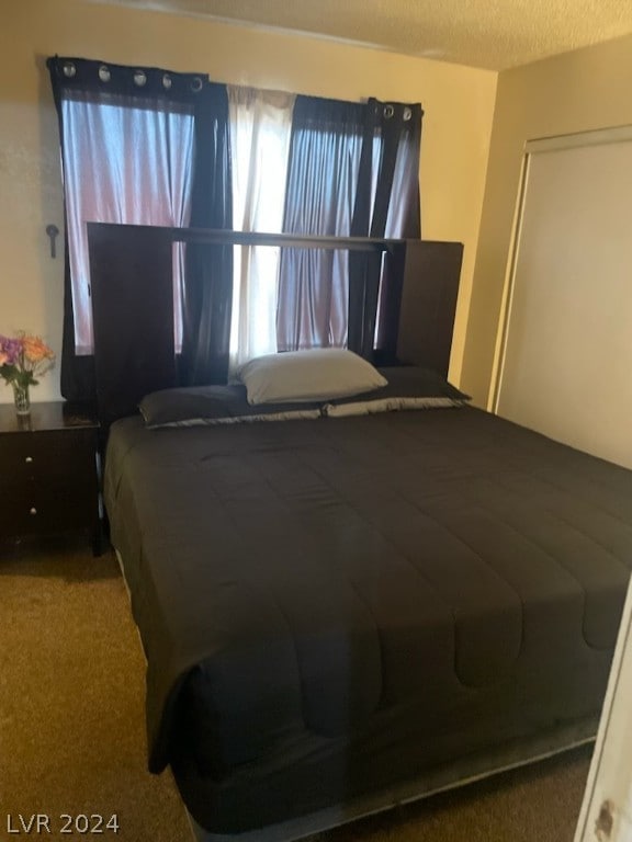 carpeted bedroom with a textured ceiling