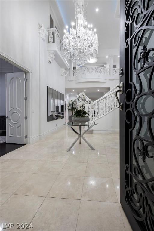 entrance foyer featuring light tile patterned flooring, a chandelier, and a high ceiling