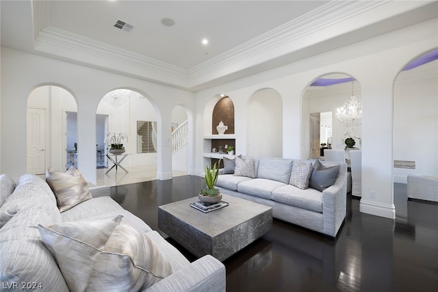 living room featuring an inviting chandelier, ornamental molding, wood-type flooring, and a raised ceiling