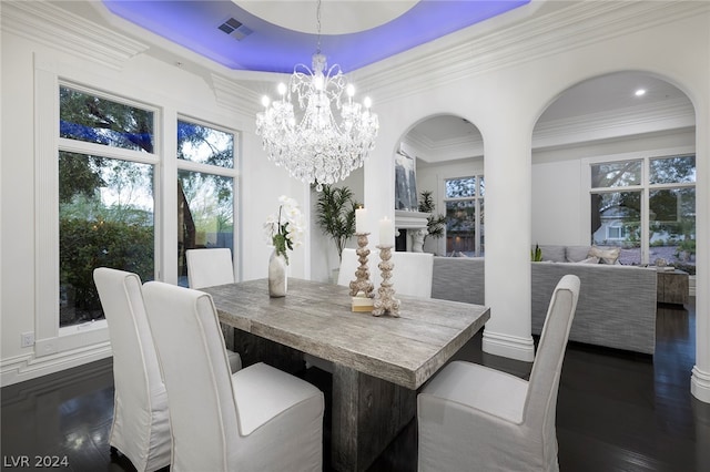 dining space featuring crown molding, dark hardwood / wood-style floors, a notable chandelier, and a tray ceiling