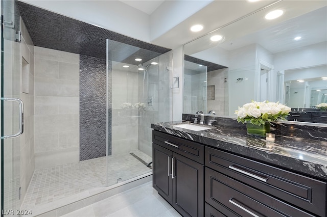 bathroom with an enclosed shower, vanity, and tile patterned floors