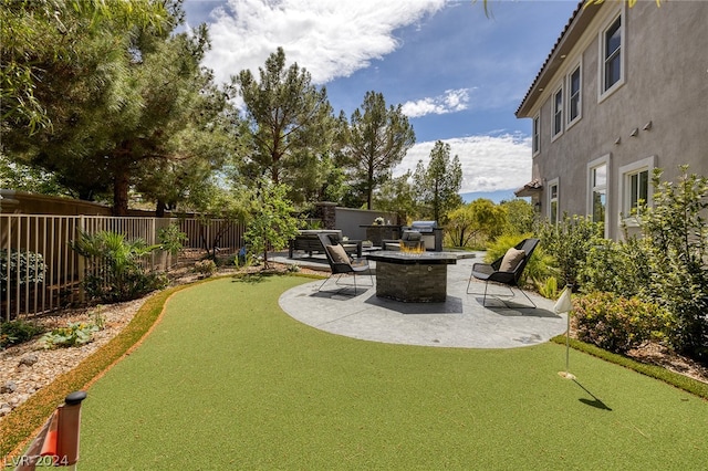 view of yard featuring a fire pit, a patio, and an outdoor kitchen